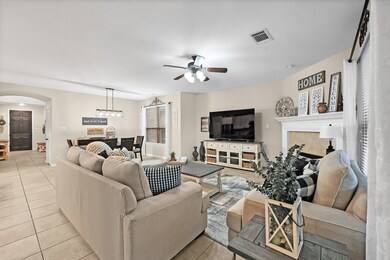 Gather the family and guests together in your lovely living room. Featuring high ceilings, dark stained ceiling fan with lighting, custom paint, gorgeous tile floors, fireplace with mantel and large windows that provide plenty of natural lighting throughout the day.