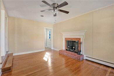 Large Family Room with fresh neutral paint, brick, wood burning fireplace, large picture window, and beautiful hardwoods