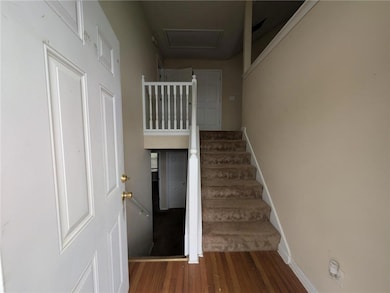Stairway with attic access, baseboards, and wood f