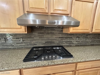 Kitchen view of stainless steel gas stovetop, ligh