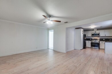 Unfurnished living room with ceiling fan, light ha