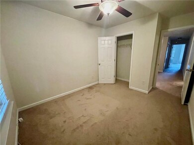 Unfurnished bedroom with carpet flooring, baseboards, a closet, and a ceiling fan