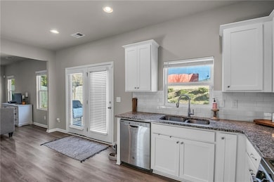 Kitchen with sink, white cabinets, dishwasher, and