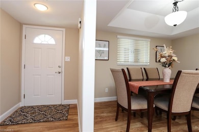 Foyer with light wood-style flooring and baseboard