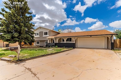 Tri-level home featuring stucco siding, an attached garage, and concrete driveway