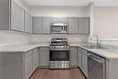 Kitchen with light stone countertops, stainless st