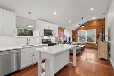 Kitchen with open floor plan, a sink, wooden wall