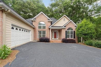 View of front facade featuring asphalt driveway, brick siding, and a garage