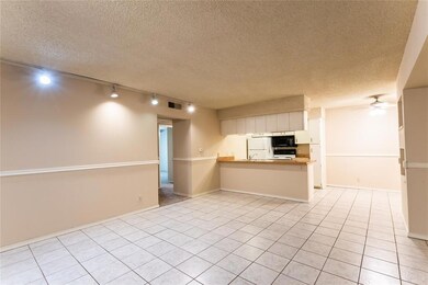 Kitchen featuring rail lighting, a peninsula, a textured ceiling, light tile patterned floors, and light countertops