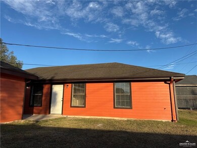 Front of Apt. D featuring fence, roof with shingles, and a yard