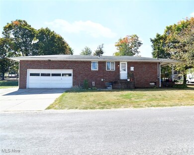 Single story home with driveway, a front lawn, brick siding, and a garage