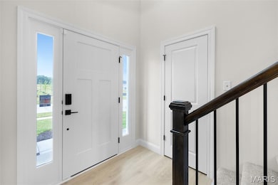 Foyer entrance with stairway and light wood-style floors