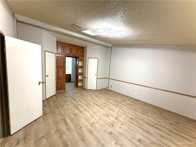 Unfurnished room with light wood-style floors and a textured ceiling