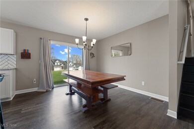 Dining room featuring dark wood-type flooring, visible vents, baseboards, and an inviting chandelier