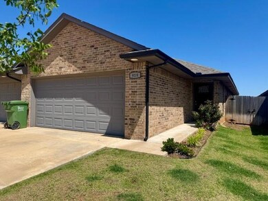 View of side of property with brick siding, an attached garage, and driveway
