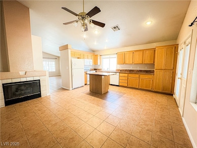 Kitchen featuring white appliances, vaulted ceilin