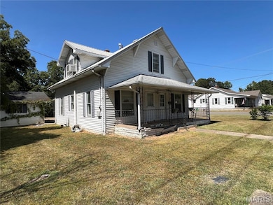 View of front of home with covered porch and a front lawn