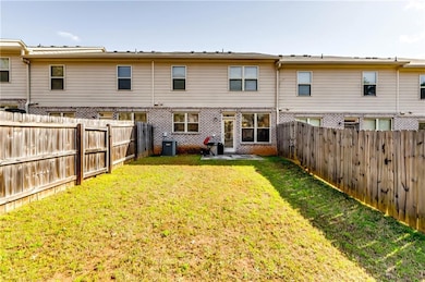Rear view of property featuring a yard, a fenced b
