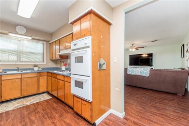Galley kitchen has double wall ovens and gas cook-
