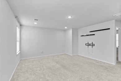 This bright room features neutral carpeting, a TV