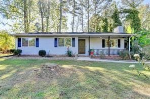 Single story home with a front yard and covered po