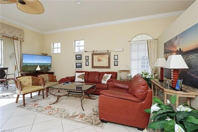 Living room with ornamental molding, tile patterned floors, and ceiling fan