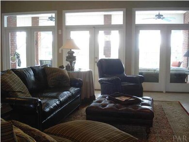 This view of the living room shows the wall of window that over look the lanai and pool enclosure.