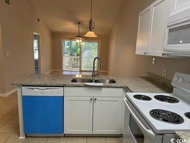 Kitchen featuring white appliances, white cabinetr