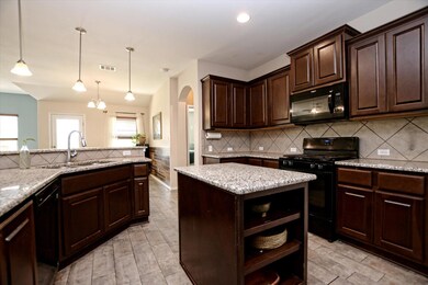 Kitchen featuring black appliances, open shelves,