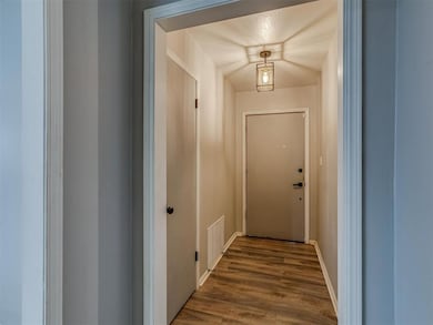 Doorway to outside with dark wood-style flooring and baseboards
