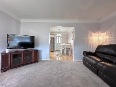 Living room featuring a chandelier and light colored carpet