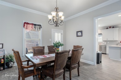 Dining area featuring crown molding, light wood-ty