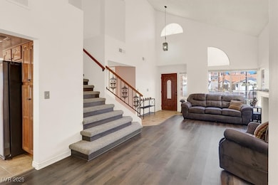Entrance foyer with high vaulted ceiling. Elegant staircase with wood-iron landing and combined design of carpet and planks.