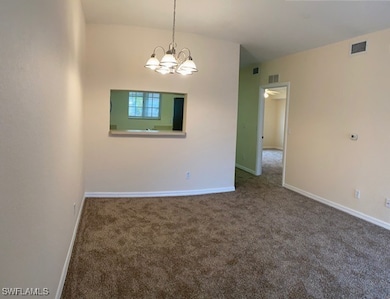 Carpeted spare room featuring baseboards, visible