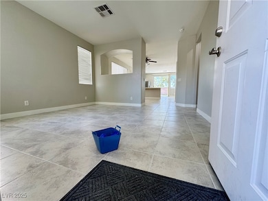 Empty room featuring arched walkways, ceiling fan,