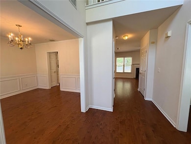 Hallway featuring a chandelier, dark wood-style fl