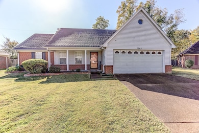 Single story home with a garage and a front lawn