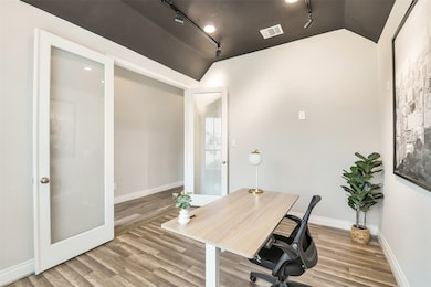 This study has French doors, luxury vinyl plank, a