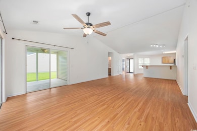 Unfurnished living room featuring ceiling fan, vau
