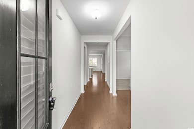 Corridor with dark wood-style flooring and baseboards