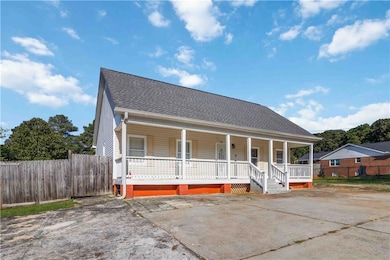 View of front facade featuring covered porch and roof with shingles