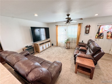 Carpeted living area with ceiling fan, a textured