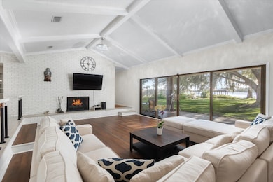Living area with a brick fireplace, wood finished floors, and brick wall