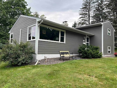 Rear view of house with a chimney and a yard
