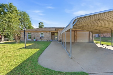 View of front of house featuring a garage, a front yard, and brick siding