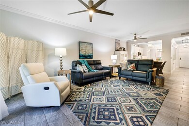 Living room featuring ceiling fan and crown moldin