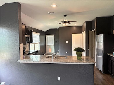 Kitchen featuring a sink, ceiling fan, visible ve