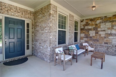 Property entrance featuring brick siding and cover