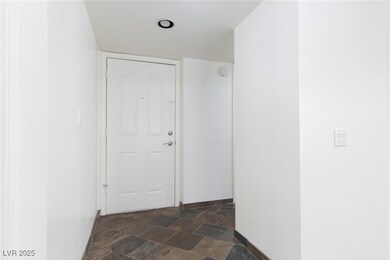 Hallway featuring dark stone finish flooring and baseboards
