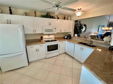 Kitchen featuring a ceiling fan, a sink, white cab